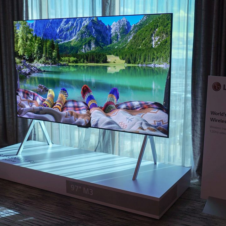 Feel clad in colorful cozy wool socks at the end of a bed that looks out over a fjord displayed on an LG M-Series OLED.