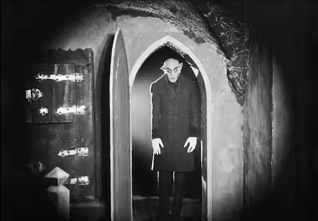 Count Orlok stands in the doorway in Nosferatu