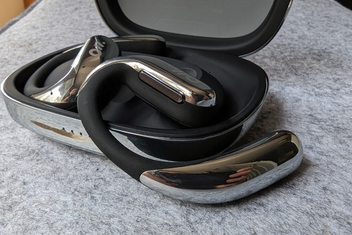 Oladance OWS Pro right earbud, sitting on case, control button seen.
