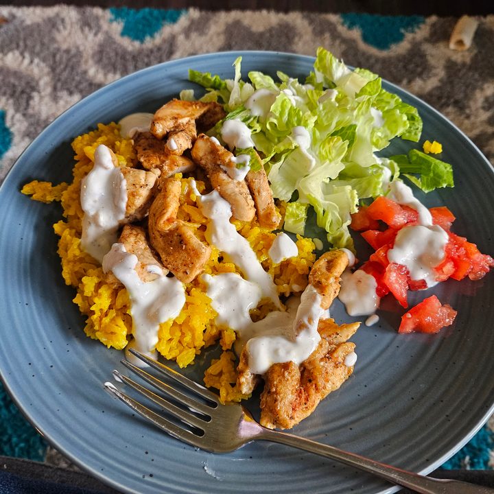 A photo from the Samsung Galaxy Z Flip 5, showing a chicken, lettuce, and tomato dish on a blue plate.