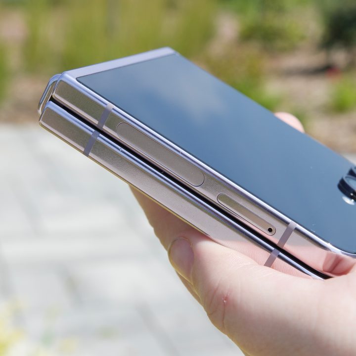 Someone holding a closed Galaxy Z Flip 5, showing how the phone folds completely flat when shut.
