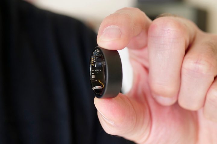 A person holding the Ultrahuman Air ring, showing the sensors.
