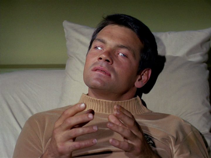 Lt. Gary Mitchell lies in a hospital bed with shining silver eyes, looking contemplative in Star Trek's "Where No Man Has Gone Before."