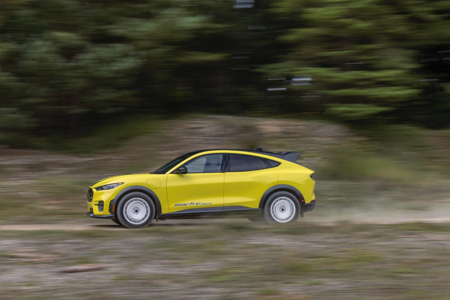 Ford Mustang Mach-E Rally driving on a dirt road.