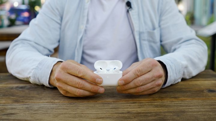 A man holds the open case of the Apple AirPods Pro 2 with USB-C and MagSafe case.