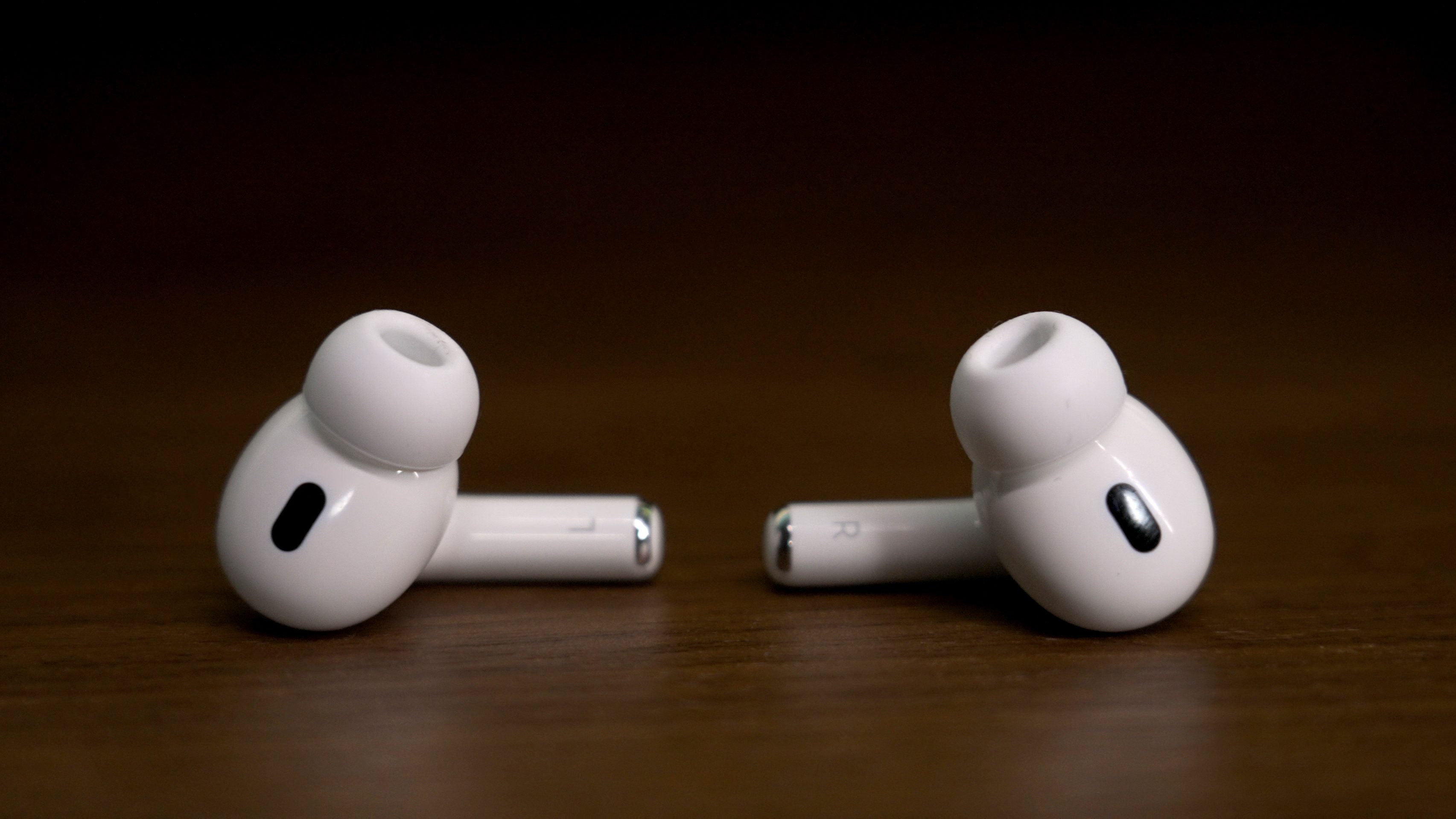 The left and right Apple AirPods Pro 2 lying on a table.