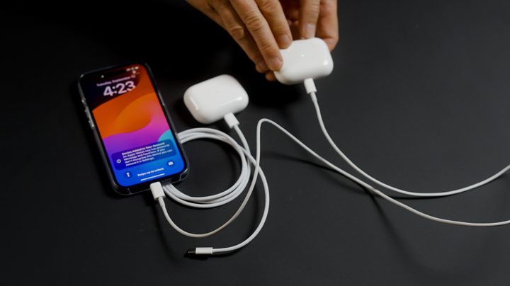 A phone charging the Apple AirPods Pro 2 with USB-C via Lightning cable.
