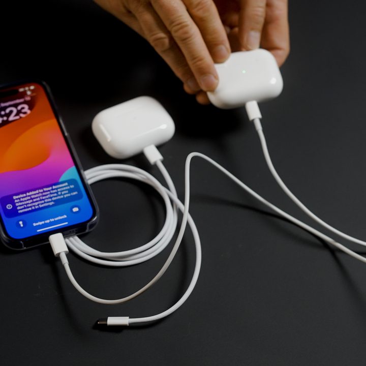 A phone charging the Apple AirPods Pro 2 with USB-C via Lightning cable.