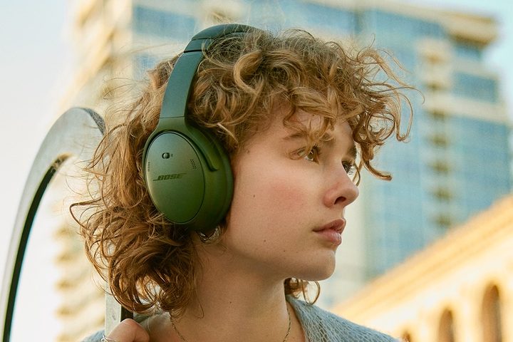 Woman wearing Bose QuietComfort Headphones in green.