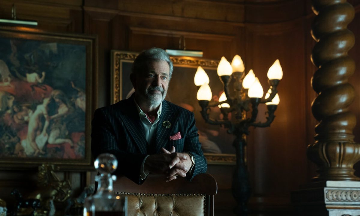 Mel Gibson looks casually menacing behind a desk