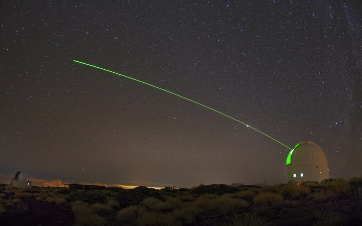 A visible green laser shone from ESA's Optical Ground Station (OGS). Part of Teide Observatory, the OGS located 2400 m above sea level on the volcanic island of Tenerife, used for the development of optical communication systems for space as well as space debris and near-Earth orbject surveys and quantum communication experiments. The laser looks curved because this picture was taken with a fisheye lens.
