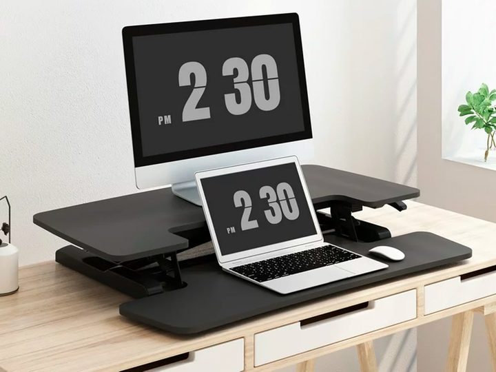 The FLEXISPOT Home Office Height Adjustable Standing Desk Converter with devices on a desktop.