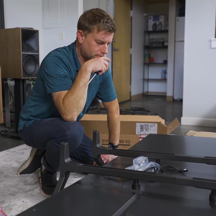 A man considers the mounting hardware of the LG M3 Wireless OLED.