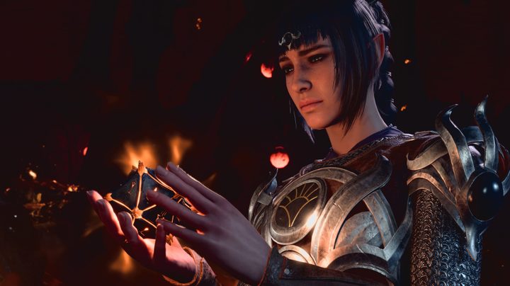 The half elf shadowheart stares pensively at glowing in her hands in Baldur's Gate 3.