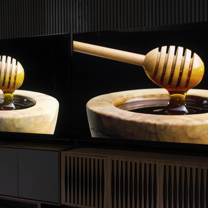 Side-by-side comparison of Sony Bravia X95L vs TCL QM8 showing a scene of honey drizzlers rising from vessels of honey.