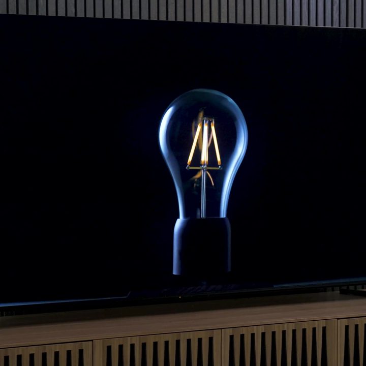 The filaments of a lightbulb glow faintly and illuminate the outline of the bulb on a Sony X95L mini-LED TV.