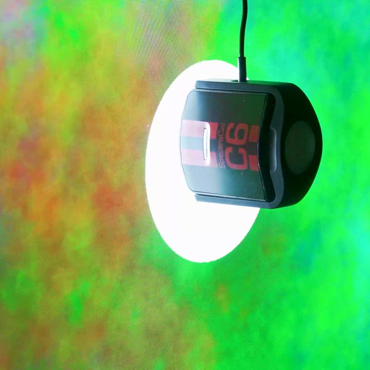 A colorometer taking measurements on a Sony X95L mini-LED TV.