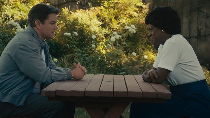 Matt Damon and Viola Davis sitting across from one another at a table outside in a scene from AIR on Prime Video.
