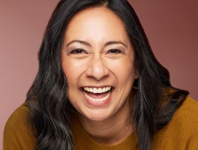 A woman smiling and wearing contacts.