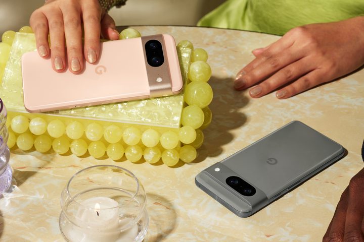 Two Google Pixel 8 phones lying next to each other on a table.