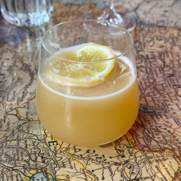 Photo from the iPhone 15 Pro Max main camera of a drink on a table of a world map.