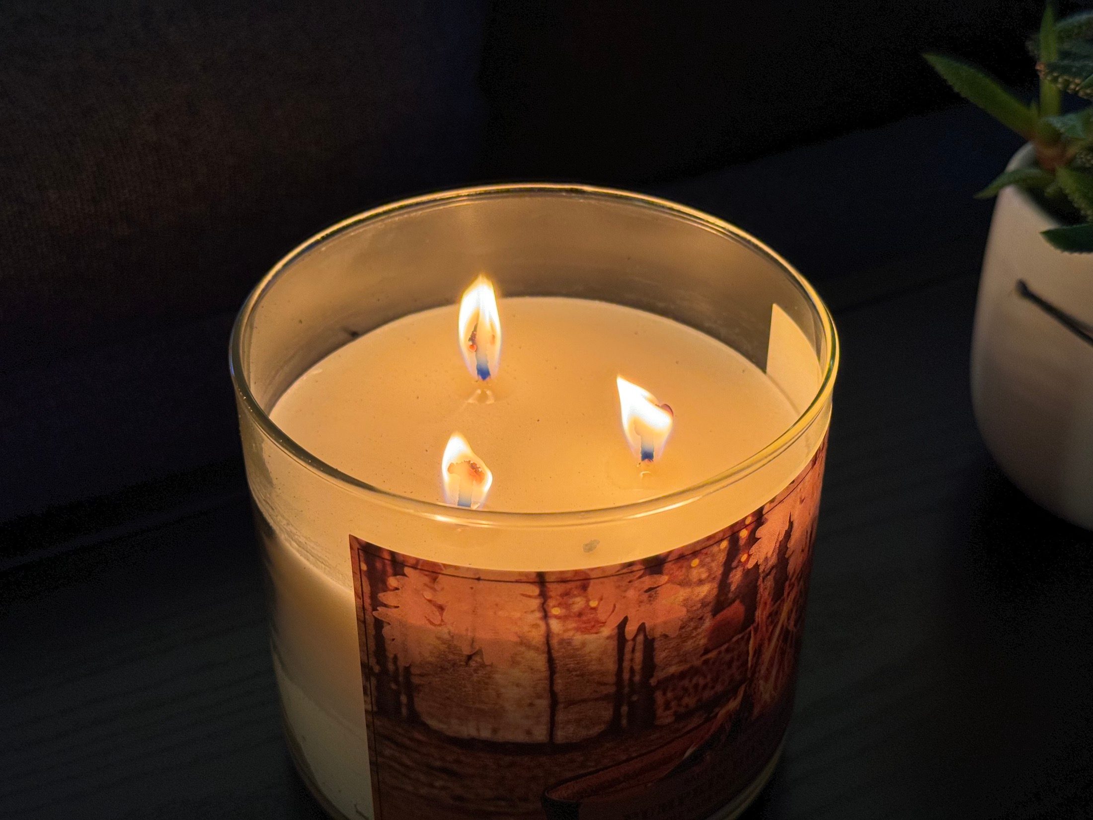 Photo of a candle in a dark room, taken with the iPhone 15 Pro Max.
