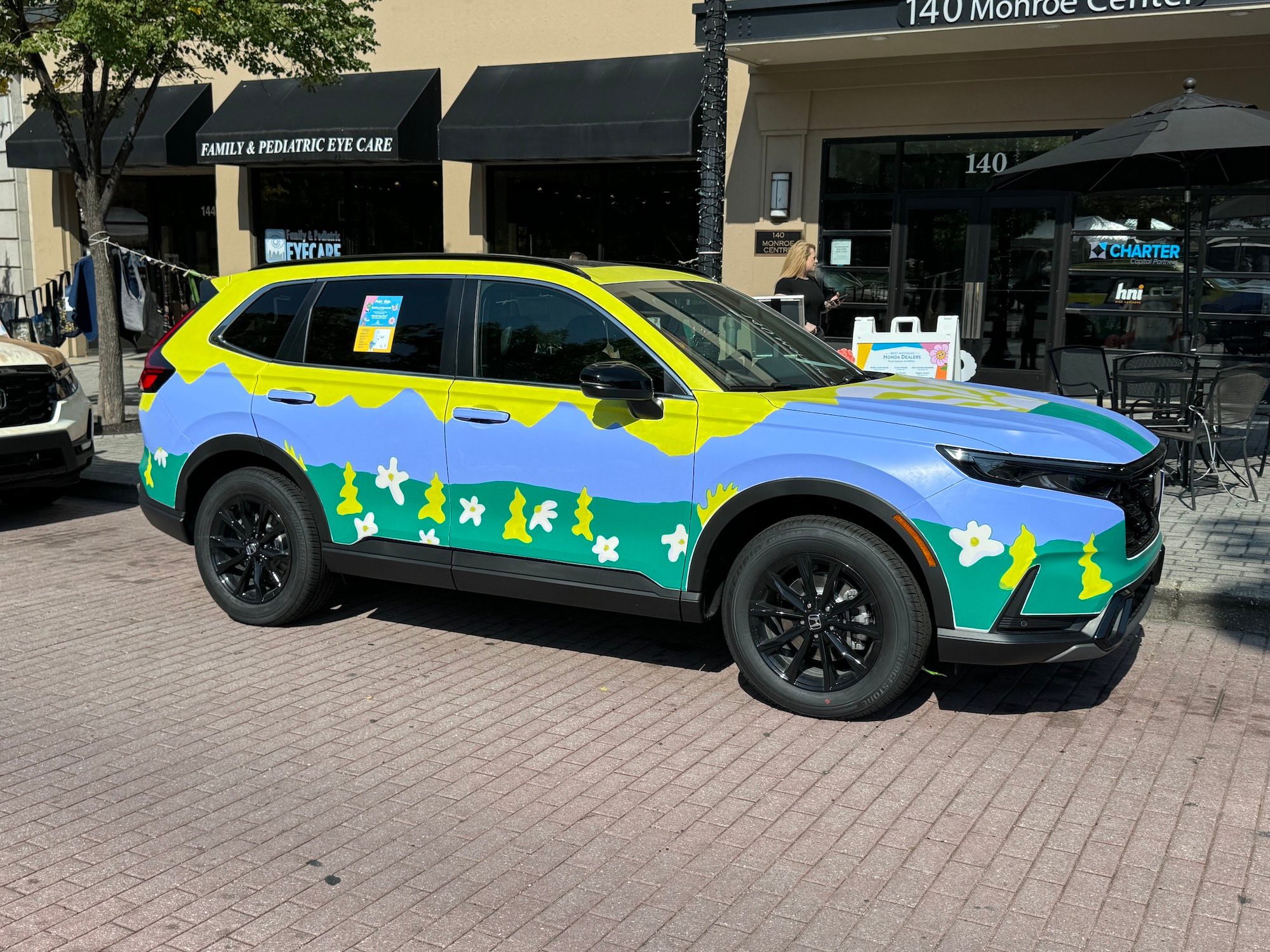 Photo from the iPhone 15 Pro Max main camera of a car painted in yellow, blue, and green.