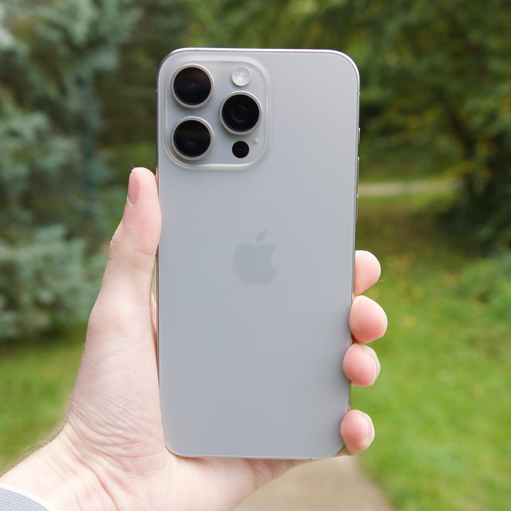 Someone holding the iPhone 15 Pro Max outside.