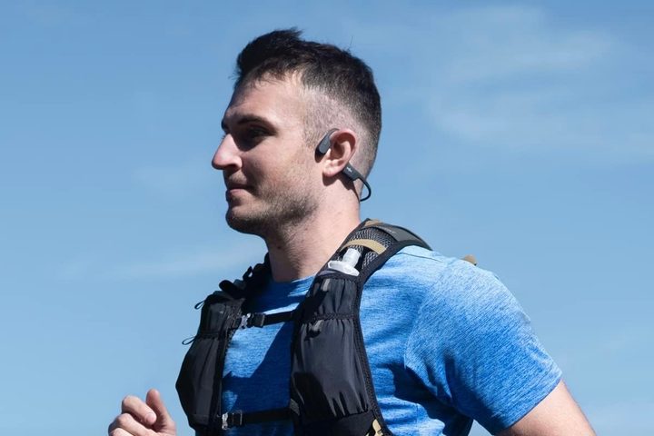 A person wearing Shokz OpenRun bone conduction headphones.