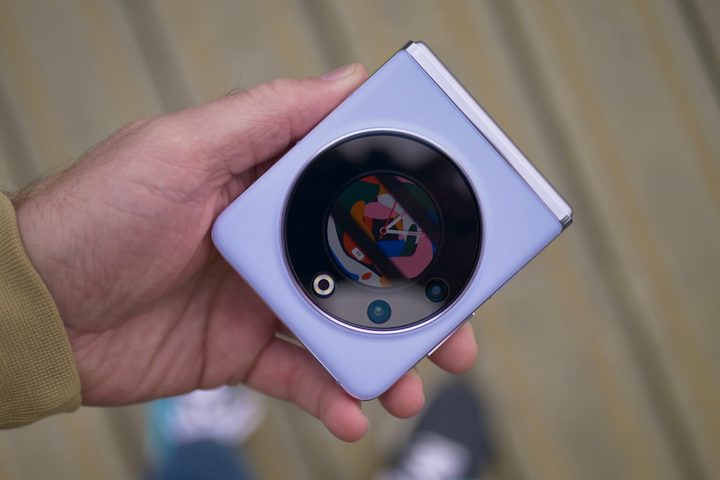 A person holding the folded Tecno Phantom V Flip.