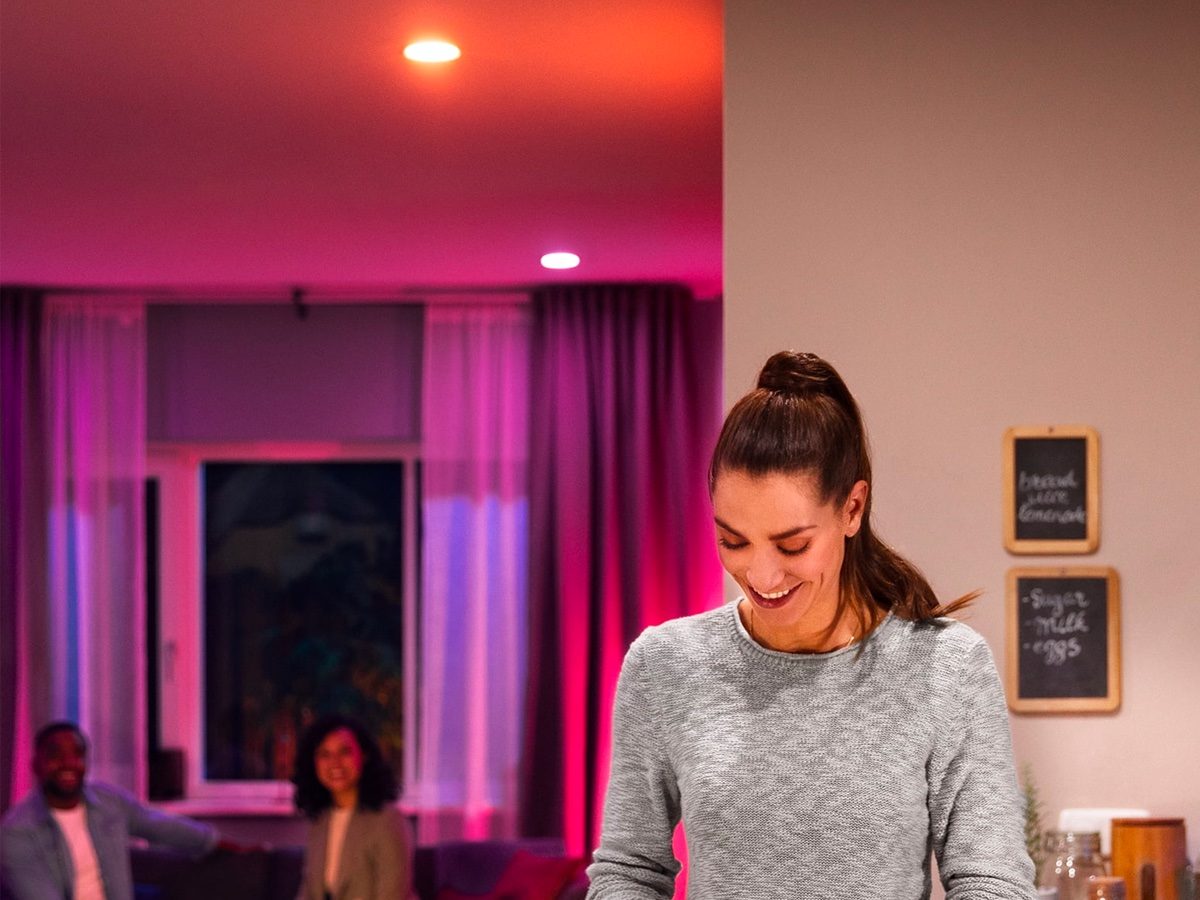 People gather in the living room under lighting by the Philips Hue recessed downlight.