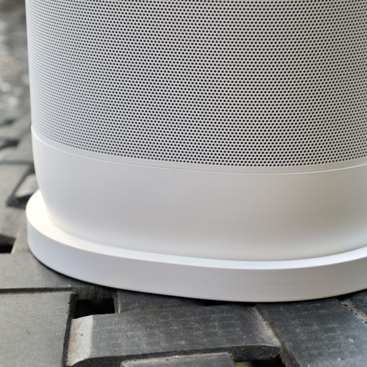 Sonos Move 2 in white sitting on charging base.