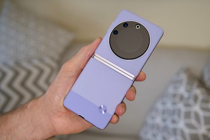 A person holding the Tecno Phantom V Flip, showing the unfolded back.