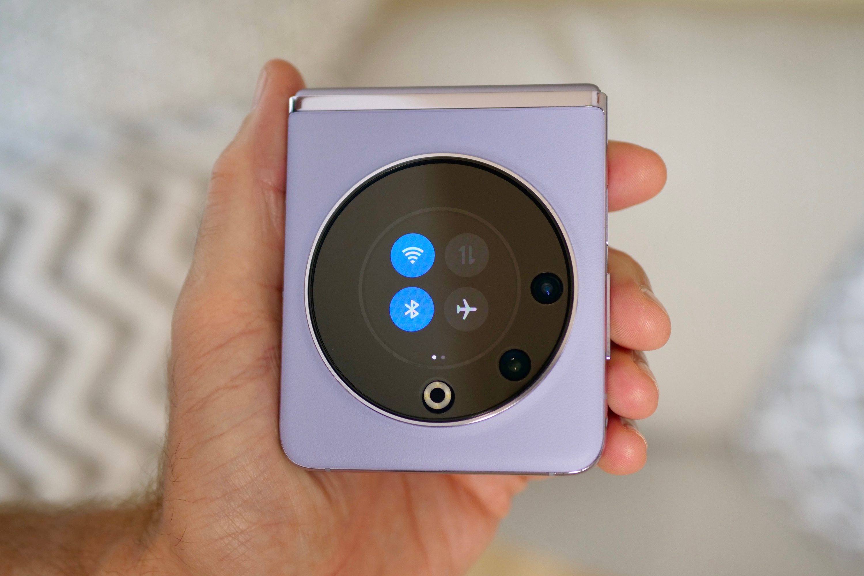 A person holding the closed Tecno Phantom V Flip, showing the Quick Settings.