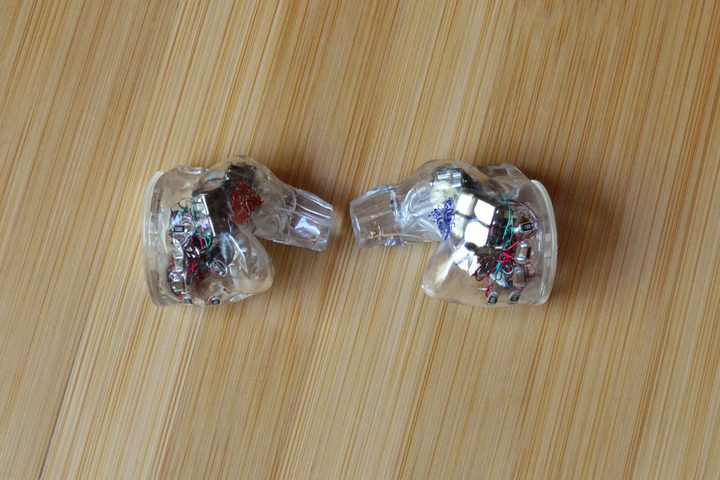 Two Ultimate Ears Premier wired IEMs without cable.
