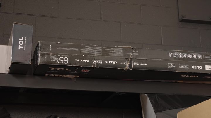 A boxed TV and other components in storage.