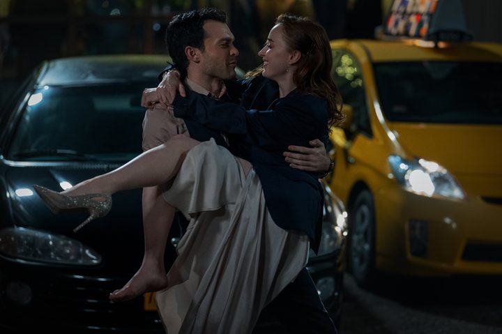 Alden Ehrenreich carries Phoebe Dynevor in Fair Play.