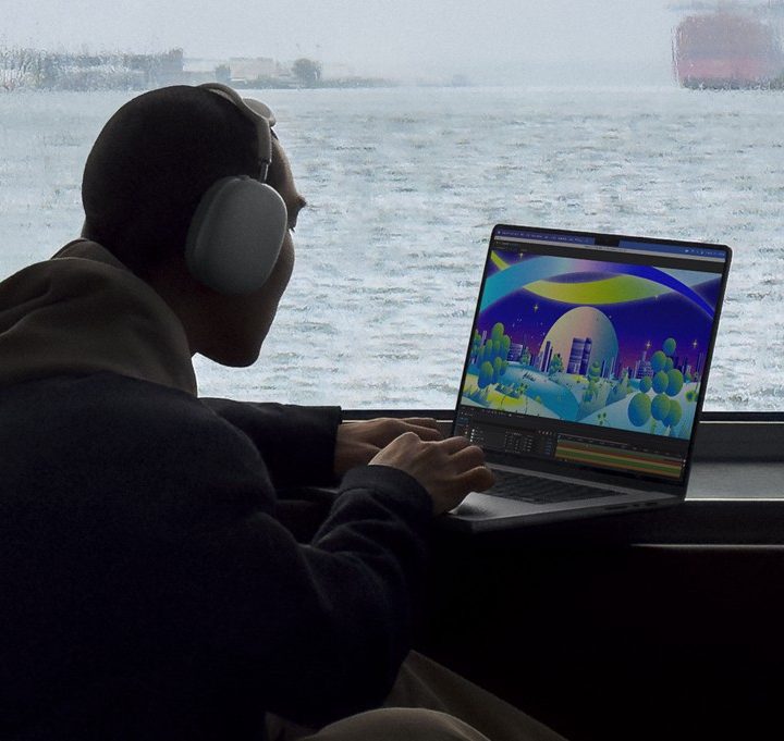 Someone using a MacBook Pro on a table in front of a scenic background.