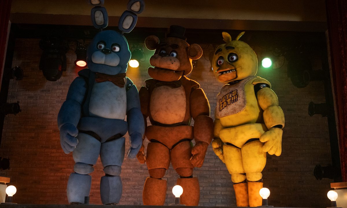 Bonnie, Freddy, and Chica stand on a stage together in Five Nights at Freddy's.