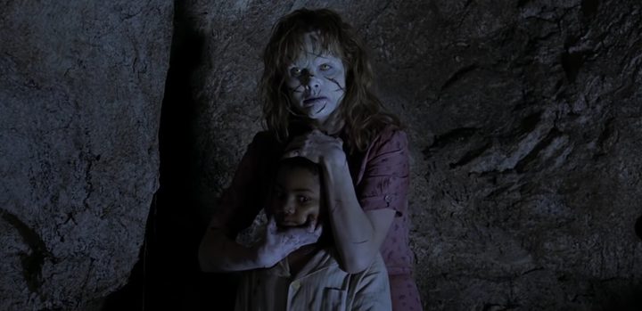 A possessed Sarah holding a child in "Exorcist: The Beginning."