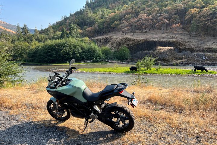 A 2023 Zero DSR-X electric motorcycle sits beside the Klickitat River in Washington.