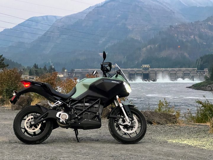 A 2023 Zero DSR-X electric motorcycle sits in front of the Bonneville Dam.