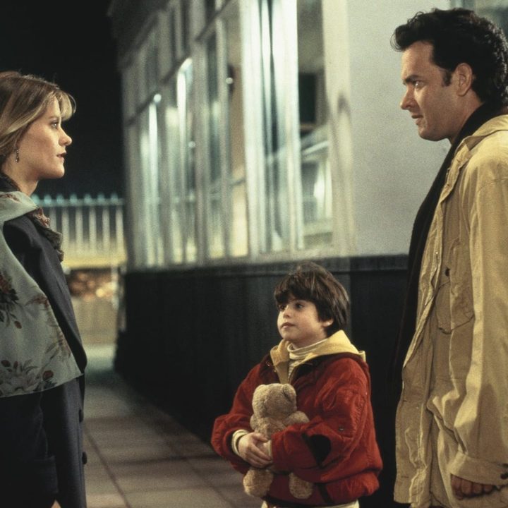 A man next to his son stands in front of a woman in Sleepless in Seattle.
