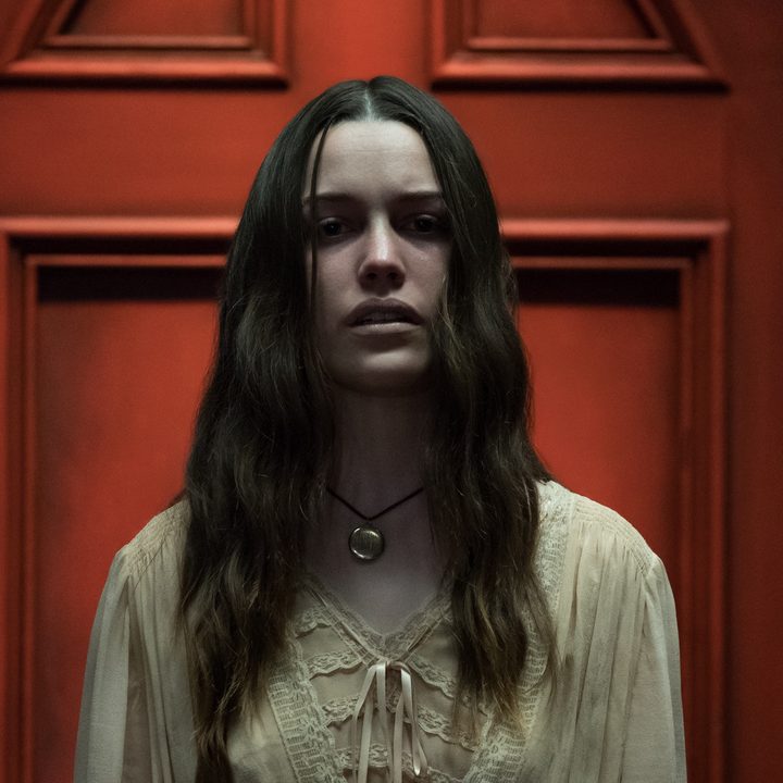 Nell stands by a red door in "The Haunting of Hill House."
