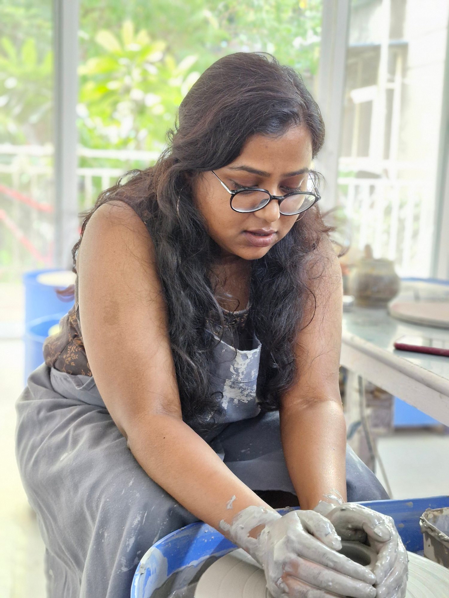 Portrait of a lady using the potters' wheel photographed with the Samsung Galaxy S23 FE.