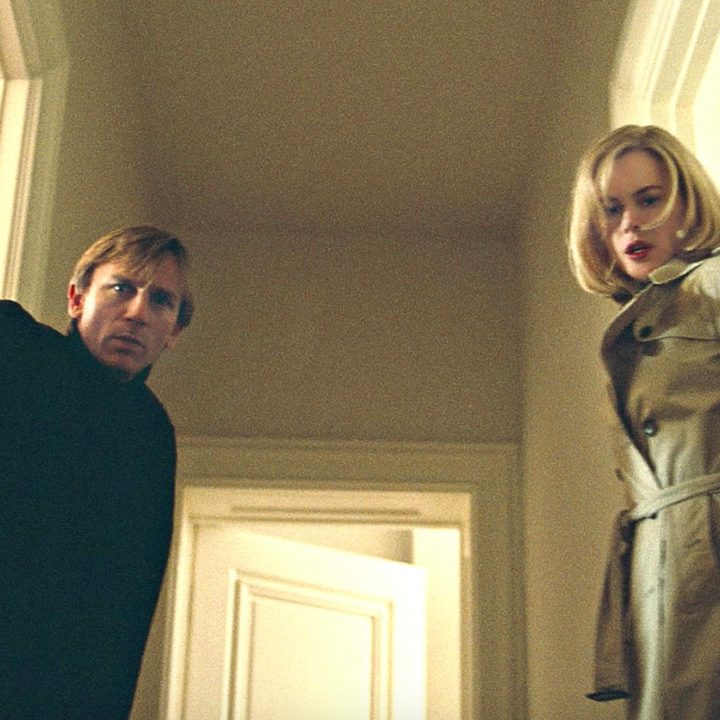 Two people stare while standing in a hallway in The Invasion.