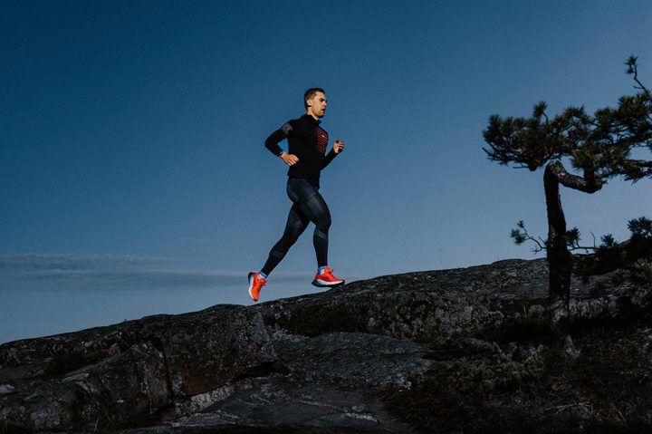 An athlete running up a hill wearing the Polar Vantage V3.