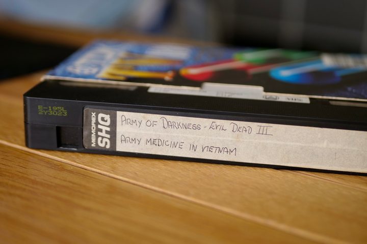 A VHS cassette with movie titles written on the front.