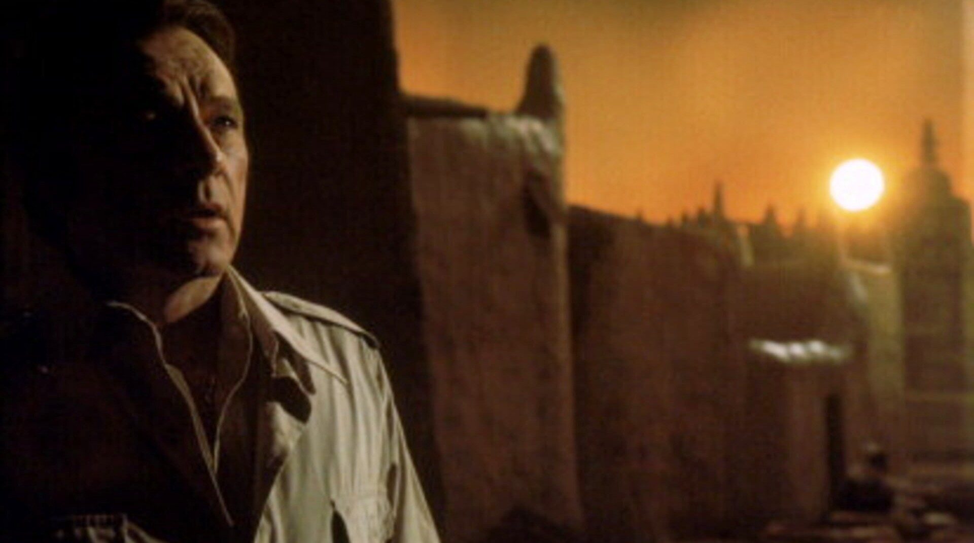 A priest looks on as the sun sets in "Exorcist II."