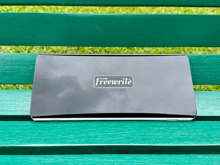 Freewrite Traveler closed on a green bench.